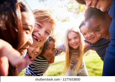 Group of smiling schoolchildren lean in to camera embracing