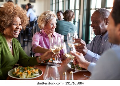 Group Of Smiling Senior Friends Meeting For Meal In Restaurant - Powered by Shutterstock