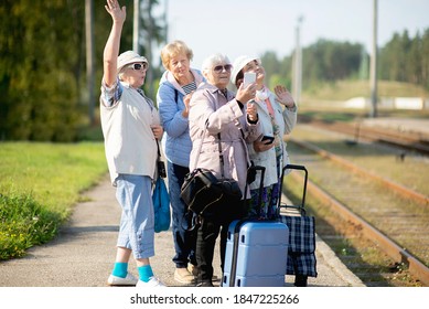 Group Of Smiling Senior Women Take A Self-portrait On A Platform Waiting For A Train To Travel During A COVID-19 Pandemic