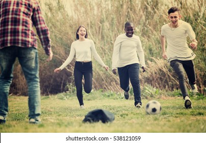 Group of smiling  teenage friends playing football outdoors in autumn day - Shutterstock ID 538121059