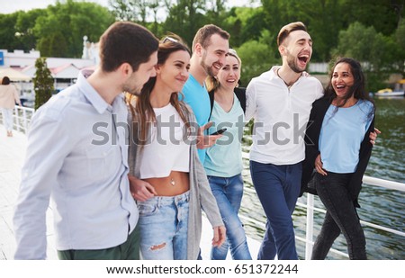 Group of smiling young and successful people on vacation on the dock.