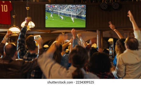 Group of Soccer Fans Cheering, Screaming, Raising Hands and Jumping During a Football Game Live Broadcast in a Sports Pub. Player in Blue Shirt Scores a Goal and Friends Celebrate. Slow Motion Footage - Shutterstock ID 2234309525