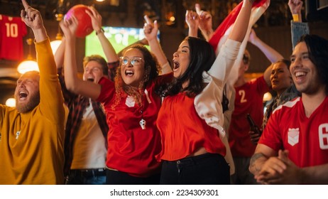 Group of Soccer Fans in Red Clothes Cheering, Screaming, Raising Hands and Jumping During a Football Game Live Broadcast in a Sports Pub. Player Scores a Goal and Friends Celebrate. Slow Motion. - Powered by Shutterstock