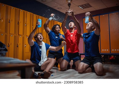 Group of soccer players celebrating victory, first place, gold trophy, shouting and screaming out of joy and splashing water. Sports, lifestyle concept. - Powered by Shutterstock