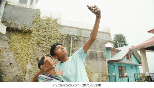 A Group Of South Asian Kids Taking Selfies On Phone And Having Fun