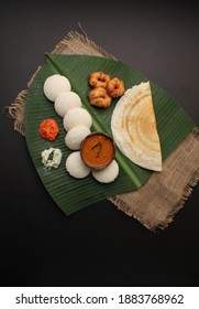 Group Of South Indian Food Like Masala Dosa, Idli, Wada Or Vada, Sambar, Served Over Banana Leaf With Colourful Coconut Chutneys