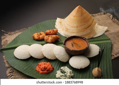 Group Of South Indian Food Like Masala Dosa, Idli, Wada Or Vada, Sambar, Served Over Banana Leaf With Colourful Coconut Chutneys