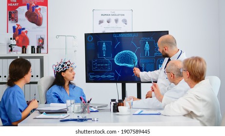 Group Of Specialist Doctors Analysing Brain Functions Using High Tech In Medical Boardroom, Nurse Testing New Innovation. Medic Studying Diagnosis Of Patients Working In Hospital Conference Room