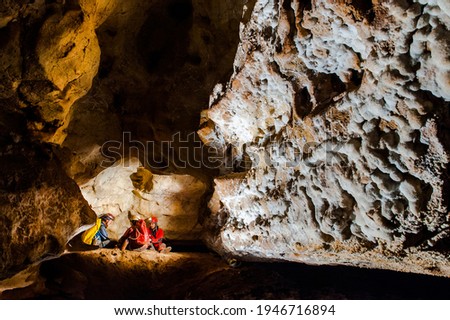 Group of speleologists resting during a cave exploration. Caving is a dangerous extreme sport practiced by professionals