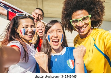 Group Of Sport Supporters At Stadium Taking Selfie - Fans Of Diverse Nations Screaming To Support Their Teams - Multi-ethnic People Having Fun And Celebrating On Tribune At A Sport Event 