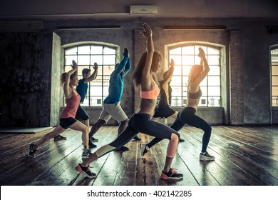 Group of sportive people in a gym training - Multiracial group of athletes stretching before starting a workout session - Shutterstock ID 402142285