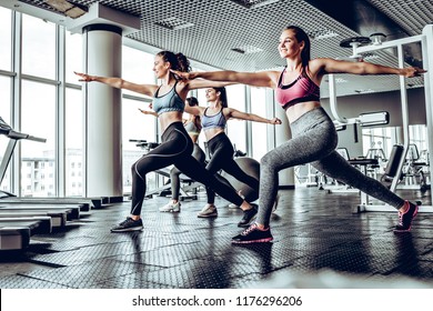 Group of sportive people in a gym training.Stretching before starting a workout session.