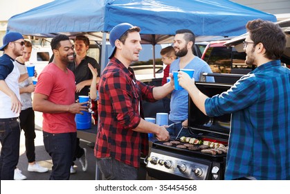 Group Of Sports Fans Tailgating In Stadium Car Park