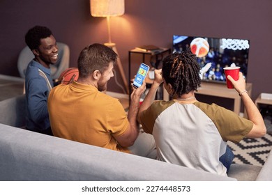 Group of sports fans watching basketball match at home on TV and cheering - Powered by Shutterstock