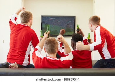 Group Of Sports Fans Watching Game On TV At Home