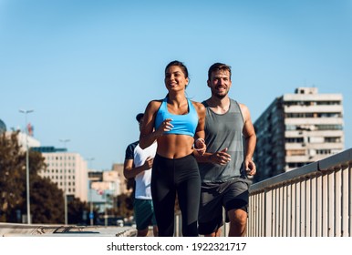 Group of sports people running in city street in morning. - Powered by Shutterstock