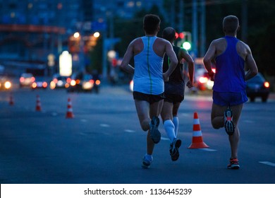 Group Of Sportsmen Running On Night Road. Healthy Lifestyle Abstract Background