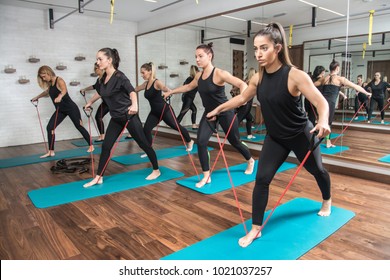 Group of sporty girls exercising with a resistance band in fitness studio. - Powered by Shutterstock