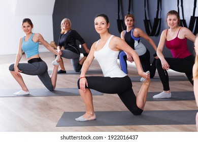 Group Of Sporty Girls Practicing Various Yoga Positions During Training Indoors