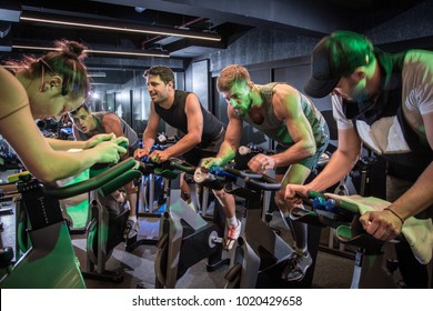 Group of sporty people cycling at gym.