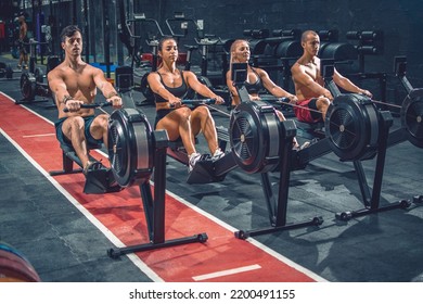 Group of sporty people working out on the rowing machines at the gym. - Powered by Shutterstock