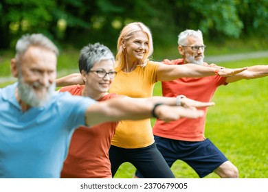 Group of sporty senior people practicing yoga outdoors, standing in Warrior two pose in green park, side view shot of diverse older men and women exercising together, enjoying active lifestyle - Powered by Shutterstock