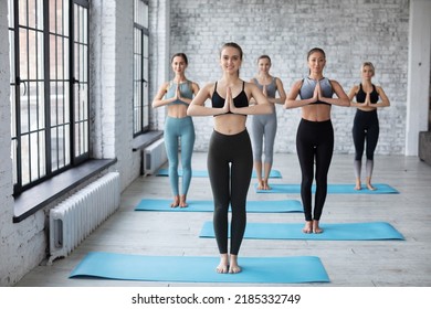 Group Of Sporty Women Doing Yoga Exercises In Gym Prayer Position Beautiful Slim Girls Wearing Sportswear Posing At Grey Fitness Center Wall Background.