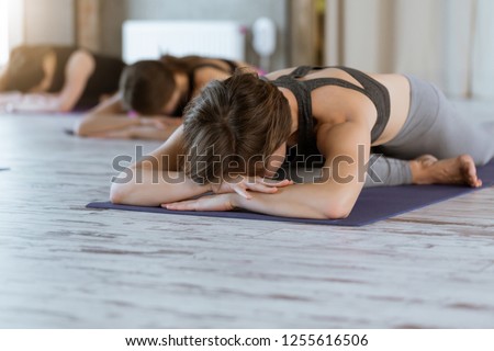 Group of sporty women in fitness studio practice yoga Kapotasana or Pigeon pose variations. Healthy lifestyle and wellness, recreation concept