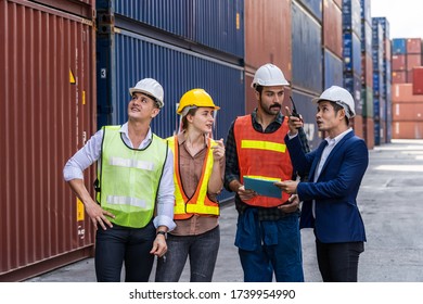 Group of staff worker standing and checking the containers box from cargo ship for export and import