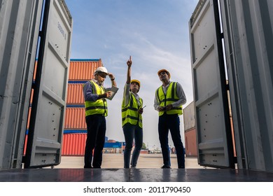 Group of staff worker standing and checking the containers box from cargo ship for export and import