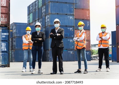 Group of staff workers standing and checking the containers box from cargo ship for export and import