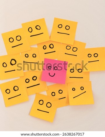 A group of sticky notes with neutral faces surrounds a single bright green note featuring a happy smile. This image symbolizes the power of positivity, standing out with joy, and embracing individuali