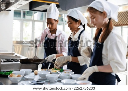 Group of student girl learning. Cooking class. culinary classroom. group of happy young woman multi - ethnic students are focusing on cooking lessons in a cooking school. 