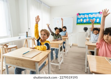 Group of student learn with teacher in classroom at elementary school. Attractive beautiful female instructor master explain and educate young children with happiness and fun activity at kindergarten. - Powered by Shutterstock