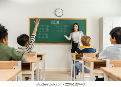 Group of student learn with teacher in classroom at elementary school. Attractive beautiful female instructor master explain and educate young children with happiness and fun activity at kindergarten. - Powered by Shutterstock