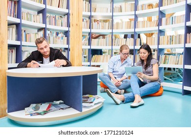 Group Of Students With Book And Tablet Computer In The University Multimedia Library