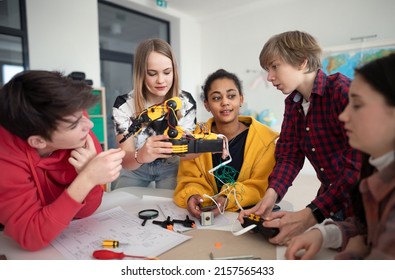 Group Of Students Building And Programming Electric Toys And Robots At Robotics Classroom