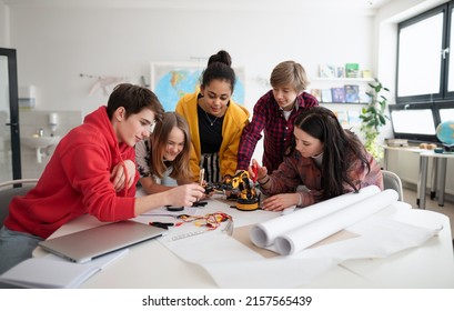 Group of students building and programming electric toys and robots at robotics classroom - Shutterstock ID 2157565439