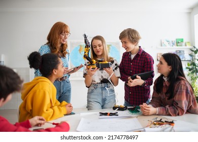 Group Of Students Building And Programming Electric Toys And Robots At Robotics Classroom