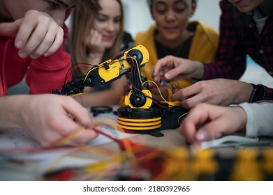 Group of students building and programming electric toys and robots at robotics classroom