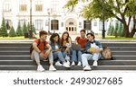 Group Of Students With Digital Tablet And Laptop Study Together Outdoors, Happy Multiethnic Young Friends Sitting On Stairs Near University Building, Using Modern Gadgets For Education, Copy Space