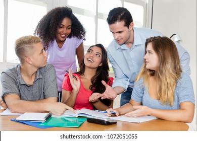 Group Of Students In Discussion With Teacher Indoor At Classroom Of University