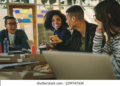 Group Of Students Eating Pizza At College Canteen. Multi-ethnic Men And Women Students Eating At University Campus Cafe.