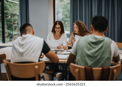 A group of students is engaged in a collaborative study session at a table, fostering teamwork and communication in a school setting, with a focus on learning and interaction.