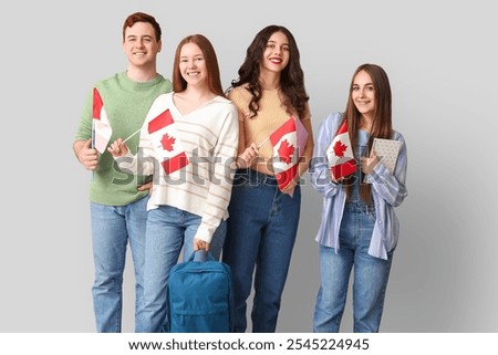 Group of students with flags of Canada on grey background
