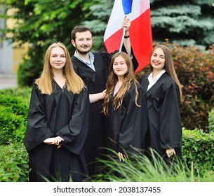 Group Of Students Graduates Of The Faculty Of Foreign Languages In Robes Hold The Flag Of France In Their Hands