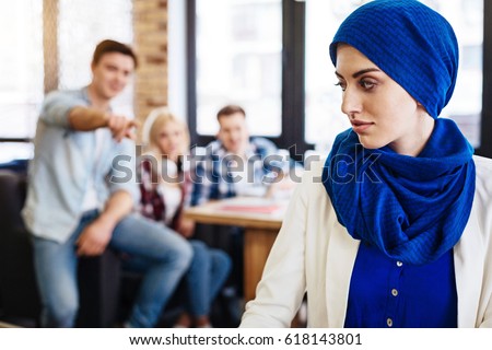 Group of students humiliating young muslim woman