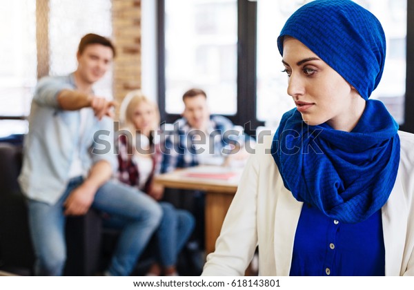 Group of\
students humiliating young muslim\
woman