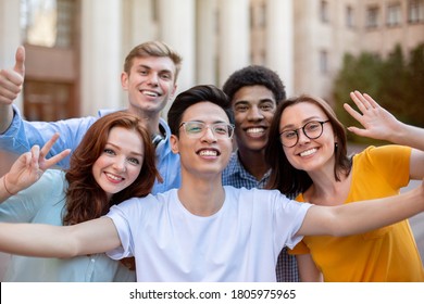 Group Of Students Making Selfie Posing Waving Hands And Gesturing V-Sign Outdoor, Happy About Entering University. Freshmen's Portrait