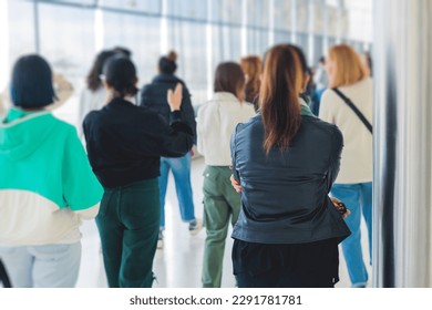 Group of students on excursion visit gallery museum with tour guide, a docent with a tourist adult visitors on an archaeology exhibition with contemporary art, paintings and exhibits
